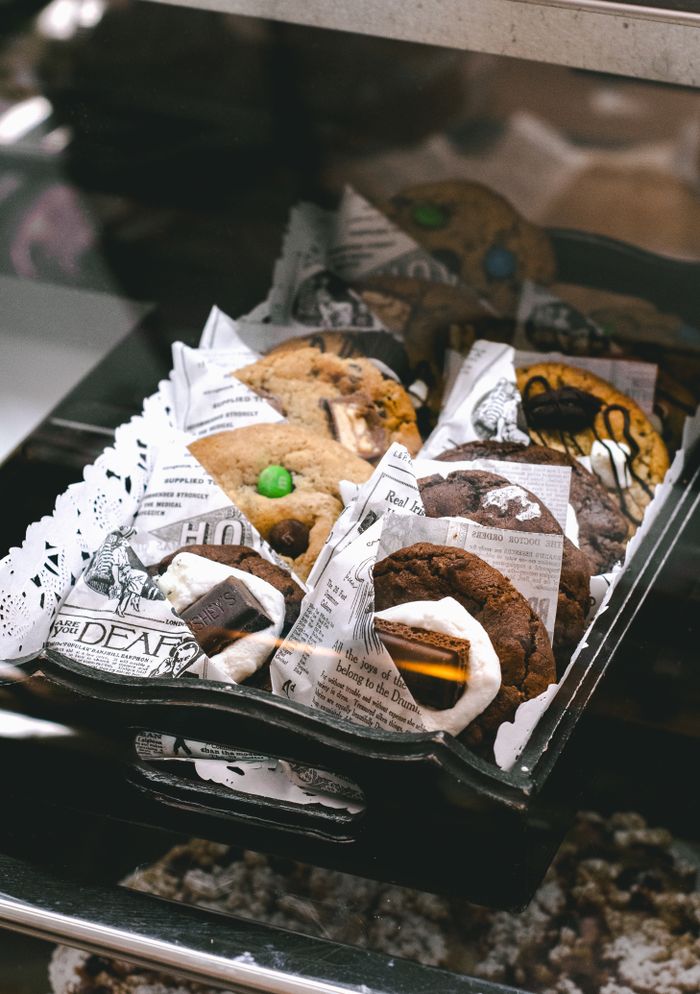 hero-img-01 Close-up of assorted gourmet cookies in a cafe display, enticing and delicious.